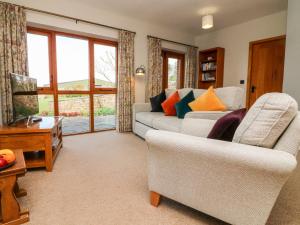 ein Wohnzimmer mit einem Sofa und 2 Stühlen in der Unterkunft Pound Cottage in Great Torrington