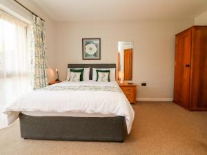 a bedroom with a large bed and a window at Pound Cottage in Great Torrington