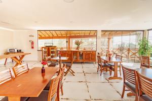 a dining room with wooden tables and chairs at Pousada Posto Monte Verde in Monte Verde