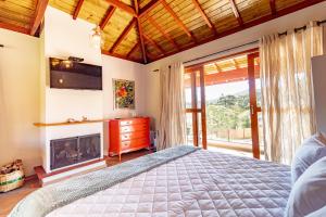 a bedroom with a bed and a fireplace at Pousada Posto Monte Verde in Monte Verde