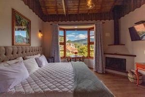 a bedroom with a bed and a large window at Pousada Posto Monte Verde in Monte Verde +93 photos