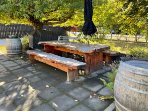 una mesa de madera con un banco y una sombrilla en Cottage on Kent, en Arrowtown