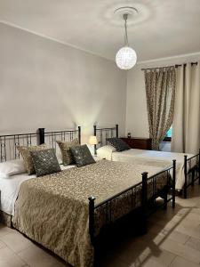 a bedroom with two beds and a chandelier at Sui Passi di Francesco in Valfabbrica