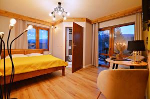 シュクラルスカ・ポレンバにあるWilla Lenaのベッドルーム1室(ベッド1台、テーブル、椅子付)