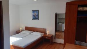 a bedroom with a bed with two candles on it at Apartments Rosa in Mali Lošinj