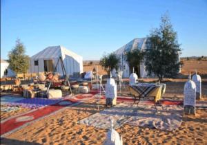 a group of people standing in front of a tent at Camels House in Merzouga