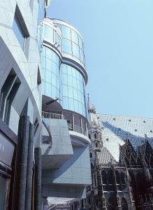 a tall glass building in a city at DO&CO Hotel Vienna in Vienna