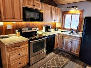 a kitchen with a stove top oven and a microwave at The Inn on Fall River & Fall River Cabins in Estes Park