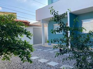 ein blaues Haus mit einem steinernen Gehweg davor in der Unterkunft Aconchego Meu in Cabo Frio