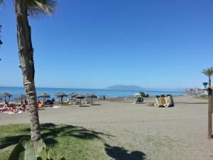 a beach with people and umbrellas and the ocean at FAY Victoria Beach in Rincón de la Victoria