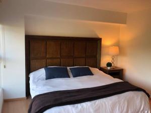 1 dormitorio con 1 cama grande y cabecero de madera en Hermoso Depto de 3 rec ubicado corazón de Santa Fe en Ciudad de México