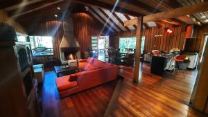 a living room with a red couch and a fireplace at Agradable casa cerca de las termas de Chillan in Las Trancas