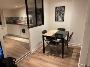 comedor con mesa y sillas y lavadora en Le Black & White, hyper centre - paisible- wifi HD- NETFLIX- proche gare -Ideal couple et business, en Niort