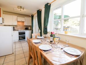 uma cozinha e sala de jantar com uma mesa de madeira e cadeiras em Orchard Cottage em Ashbourne