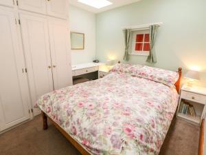 アシュボーンにあるOrchard Cottageのベッドルーム1室(花柄のベッドカバー付)