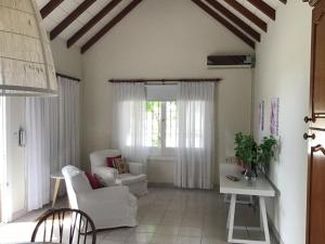ein Wohnzimmer mit weißen Möbeln und einem Fenster in der Unterkunft Casa al rio in San Pedro