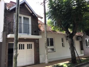 Cette maison dispose de portes de garage blanches et d'un balcon. dans l'établissement Casa al rio, à San Pedro