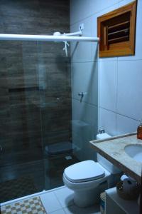 uma casa de banho com um chuveiro, um WC e um lavatório. em Belladora Pousada em Barra Grande