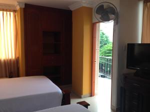 Schlafzimmer mit einem Bett, einem TV und einem Balkon in der Unterkunft Hotel Vans Valledupar in Valledupar