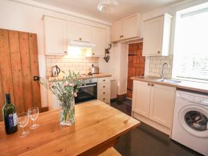 a kitchen with a table with a vase of flowers on it at Siskin in Machynlleth