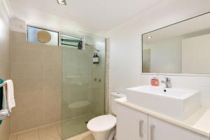 a bathroom with a shower, toilet and sink at Reef Gateway Apartments in Cairns