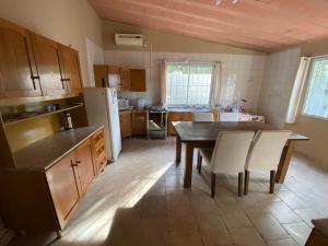 Casa agradável com lareira في شوي: مطبخ مع طاولة وكراسي وثلاجة