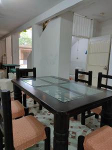 a dining room with a glass table and chairs at Hostal Pakal King in Palenque