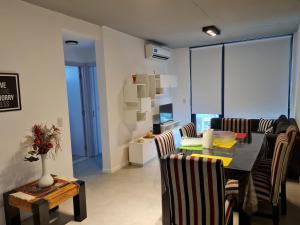 comedor y sala de estar con mesa y sillas en Hermoso Departamento 3 Ambientes en Tigre