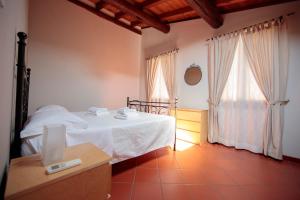 une chambre avec un lit blanc et une fenêtre dans l'établissement Corte Roveggia - Bilocale Monet, à Vérone