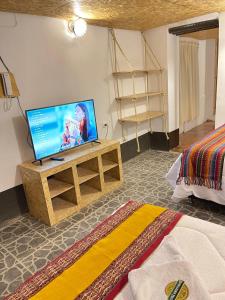 sala de estar con TV sobre una mesa de madera en Hotel Highgarden Ollantaytambo, en Ollantaytambo