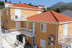 an apartment building with white balconies and orange roofs at Apartments Villa Eva in Slano
