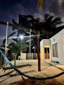 a swing in front of a house with palm trees at Casa De Los Peces in San Crisanto