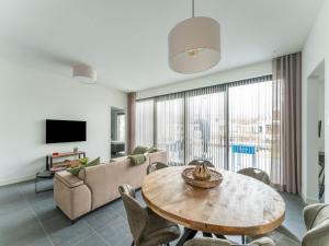 a living room with a table and a couch at Family villa in Zeewolde at the waterfront with recreation in Zeewolde