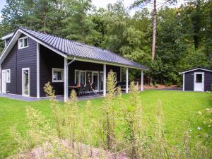 a small black house with a large yard at Beautiful house with covered terrace, located in a holiday park in Rhenen in Rhenen