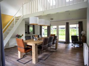 a dining room with a wooden table and chairs at Beautiful house with covered terrace, located in a holiday park in Rhenen in Rhenen