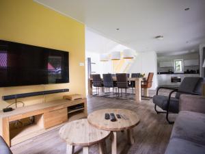 a living room with a large television and a table at Beautiful house with covered terrace, located in a holiday park in Rhenen in Rhenen