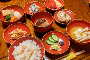 a group of bowls of food on a wooden table at 海蔵寺 宿坊 櫻海 in Ine