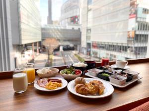 a table with plates of food on a table with a window at Akihabara Washington Hotel in Tokyo