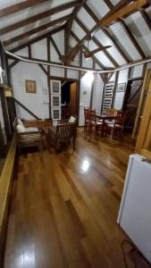a living room with wooden floors and a table and chairs at Les Hauts de Bergette in Petit-Bourg +1 photo