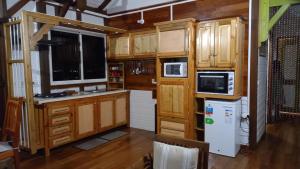 a kitchen with wooden cabinets and a refrigerator at Les Hauts de Bergette in Petit-Bourg