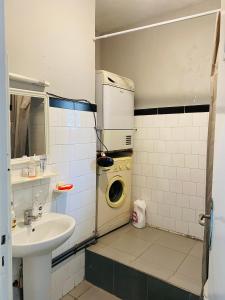 a bathroom with a sink and a washing machine at Charmant appartement au centre-ville de tanger in Tangier