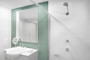 a bathroom with a sink and a shower with a mirror at Peppers Salt Resort & Spa in Kingscliff