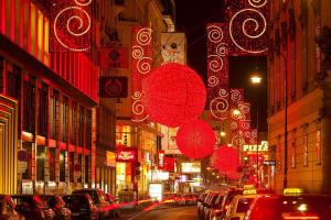 a busy city street at night with christmas lights at DO&CO Hotel Vienna in Vienna