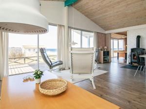 uma sala de estar com uma mesa e cadeiras e uma grande janela em Holiday home Farsø XVIII em Farsø
