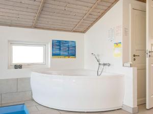 10 person holiday home in Thisted في Nørre Vorupør: حوض أبيض كبير في الحمام مع نافذة