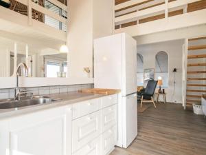 10 person holiday home in Thisted في Nørre Vorupør: مطبخ مع دواليب بيضاء ومغسلة