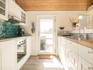 10 person holiday home in Thisted في Nørre Vorupør: مطبخ بدولاب بيضاء وباب مفتوح