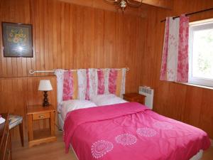 a bedroom with a bed with a pink blanket at Granite stone house with fireplace, Plouguerneau in Plouguerneau