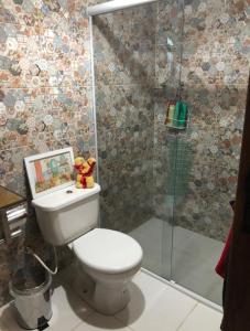 La salle de bains est pourvue de toilettes et d'une douche en verre. dans l'établissement Casa de campo com piscina em Paty do alferes, à Paty do Alferes