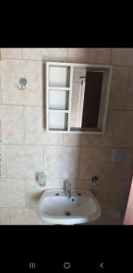 a bathroom with a sink and a mirror at La Peninsula in Neuquén